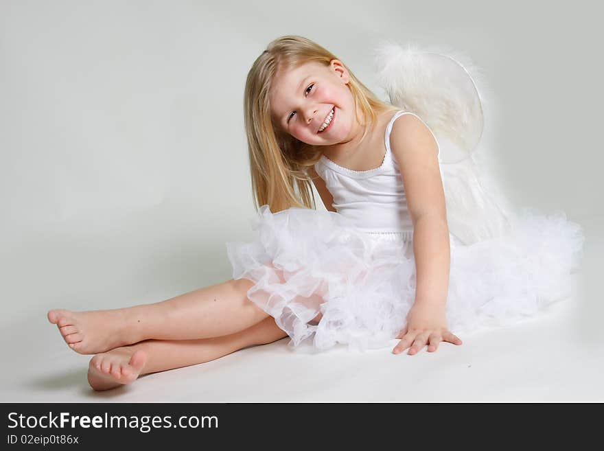 Studio shot of little smiling angel girl