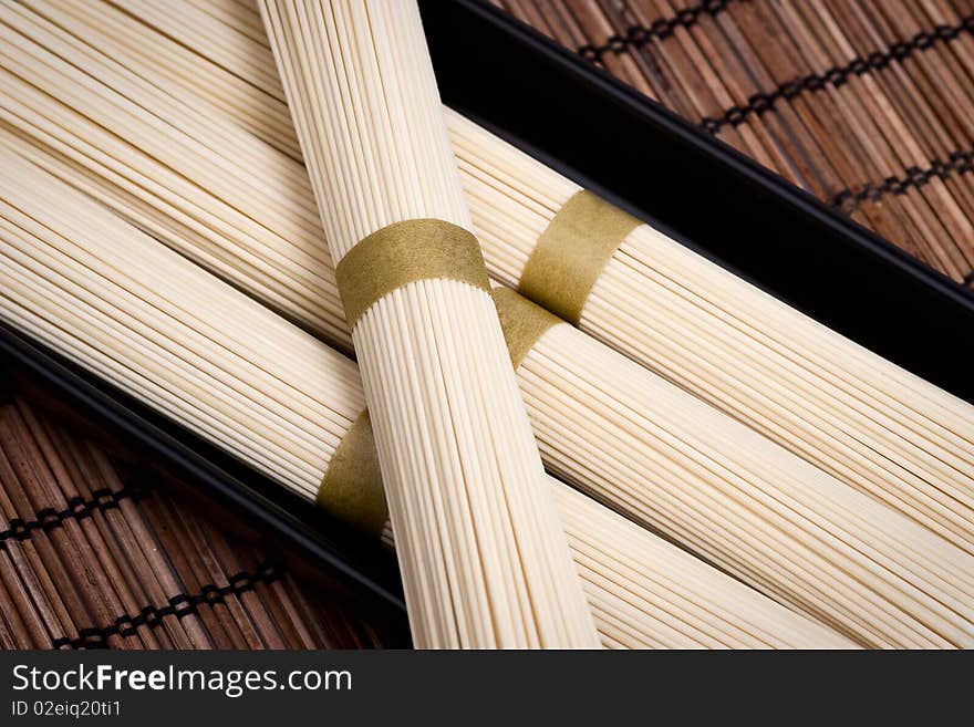 Unboiled oriental noodles on a rural mat. Selective focus. Unboiled oriental noodles on a rural mat. Selective focus.