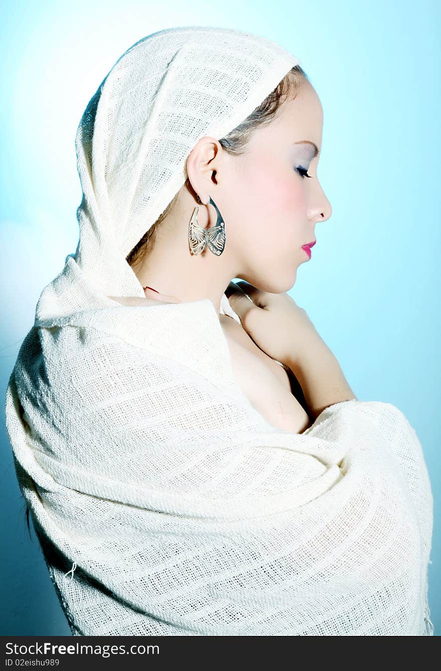 Woman with a white robe on his head and body over blue and light background