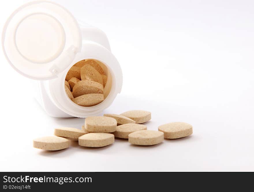 White pills and bottle on light background. White pills and bottle on light background