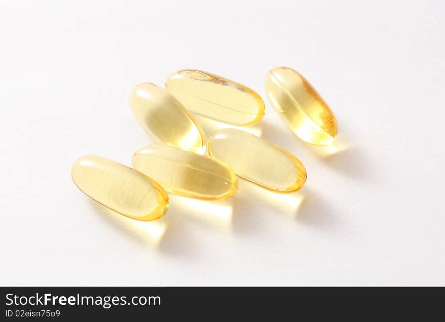 Six yellow pills on light and white background. Six yellow pills on light and white background