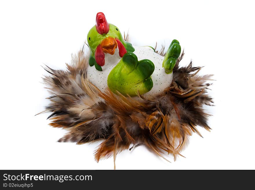 Big ceramic hen in nest which is made of feather. Easter decoration, isolated. Big ceramic hen in nest which is made of feather. Easter decoration, isolated.