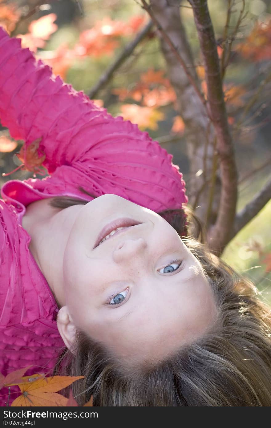 Cute young blond girl having fun hanging upside down in a tree. Cute young blond girl having fun hanging upside down in a tree