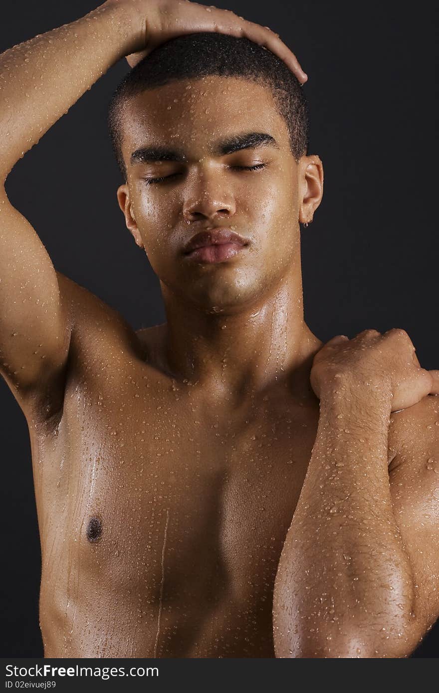 Drops of the water on naked body of a young man on black background. Drops of the water on naked body of a young man on black background.