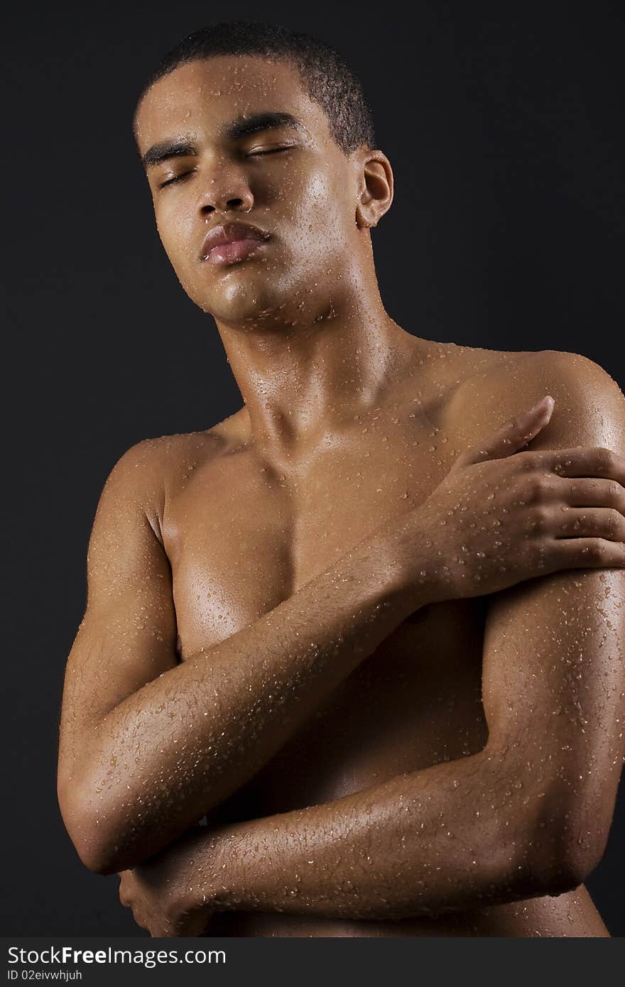 Drops of the water on naked body of a young man on black background. Drops of the water on naked body of a young man on black background.