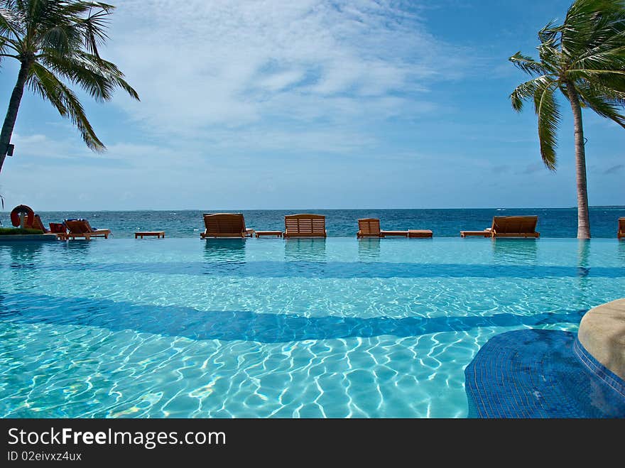 Plank bed with a chair on white sand against azure ocean. Plank bed with a chair on white sand against azure ocean