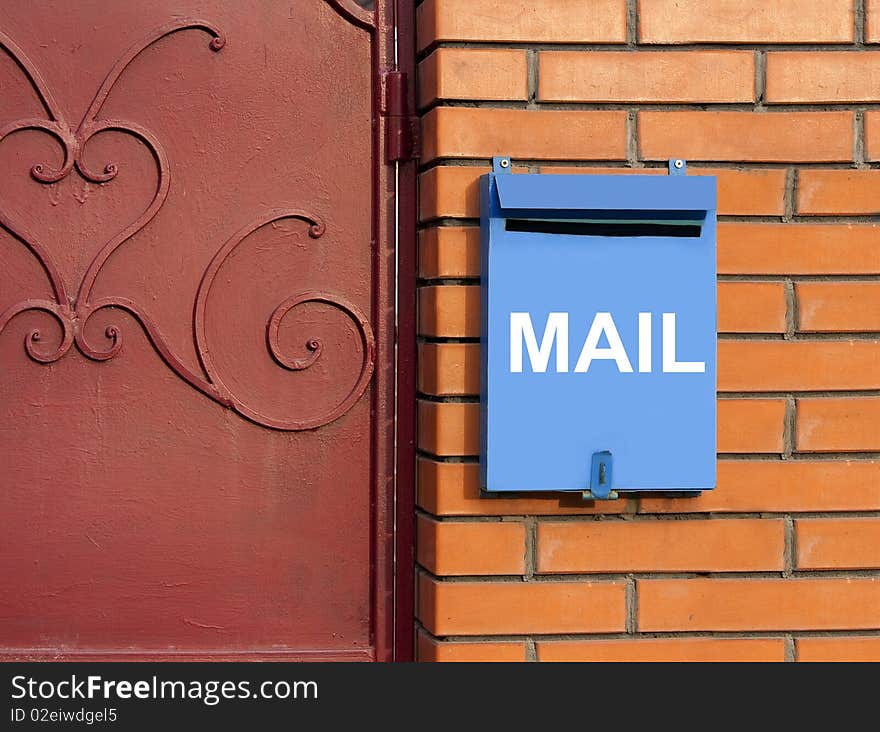 Blue mailbox on yellow brick wall