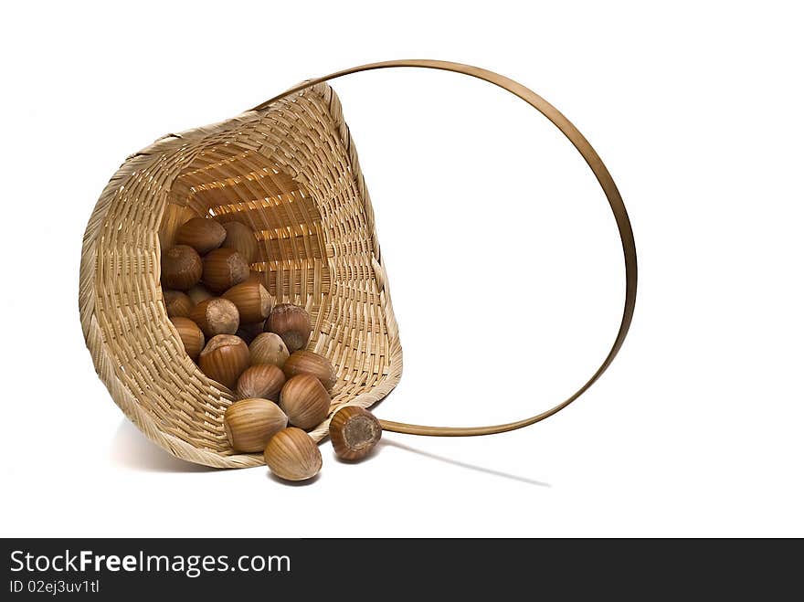 One basket with hazelnuts isolated on a white background. One basket with hazelnuts isolated on a white background.