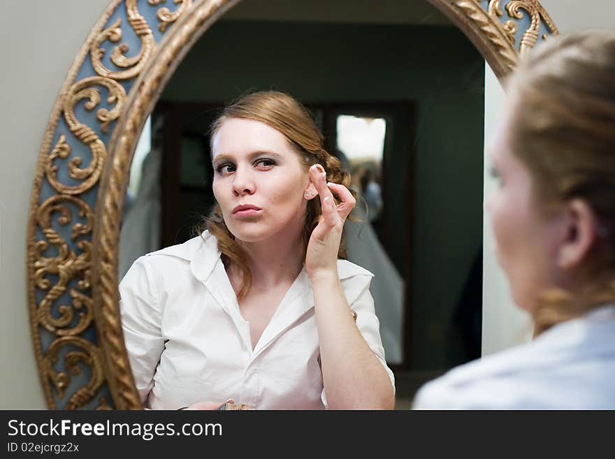 Bride puckering lips while putting on her makeup. Bride puckering lips while putting on her makeup.