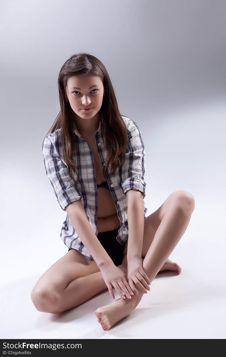 Young barefoot beautiful woman in checked shirt. Young barefoot beautiful woman in checked shirt