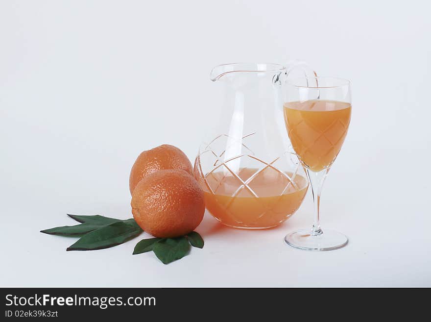 Two oranges, jug and a glass of orange juice. Two oranges, jug and a glass of orange juice.