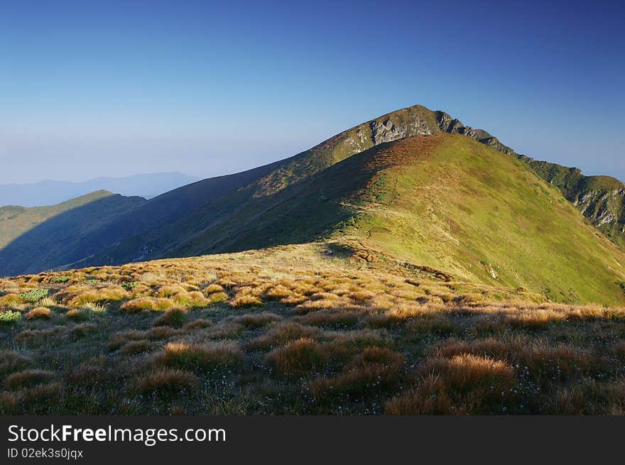 Morning in the mountains, the first beams of a rising sun shine mountains. Ukraine, Carpathians. Morning in the mountains, the first beams of a rising sun shine mountains. Ukraine, Carpathians