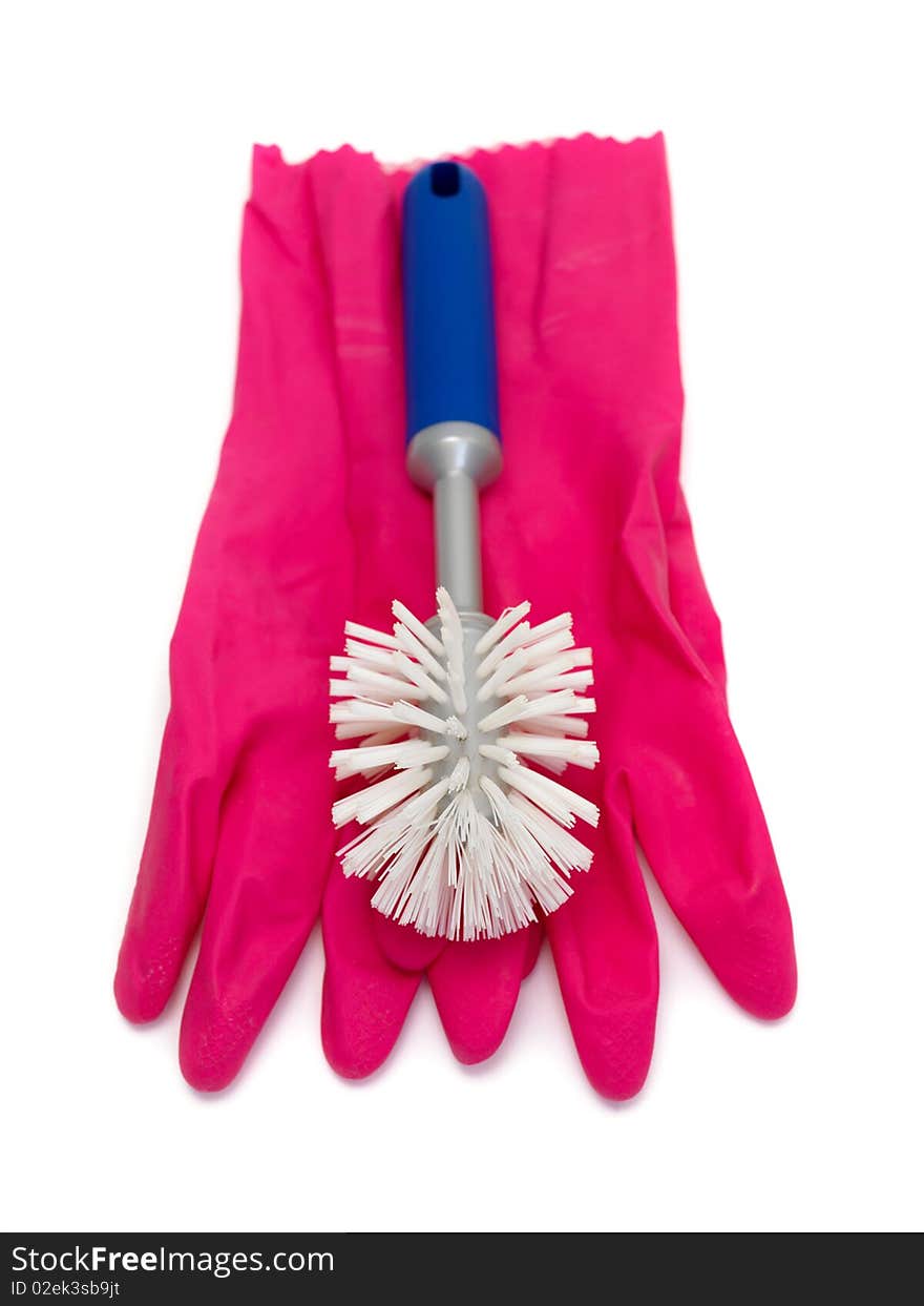 A scrubbing brush and rubber gloves  isolated against a white background. A scrubbing brush and rubber gloves  isolated against a white background