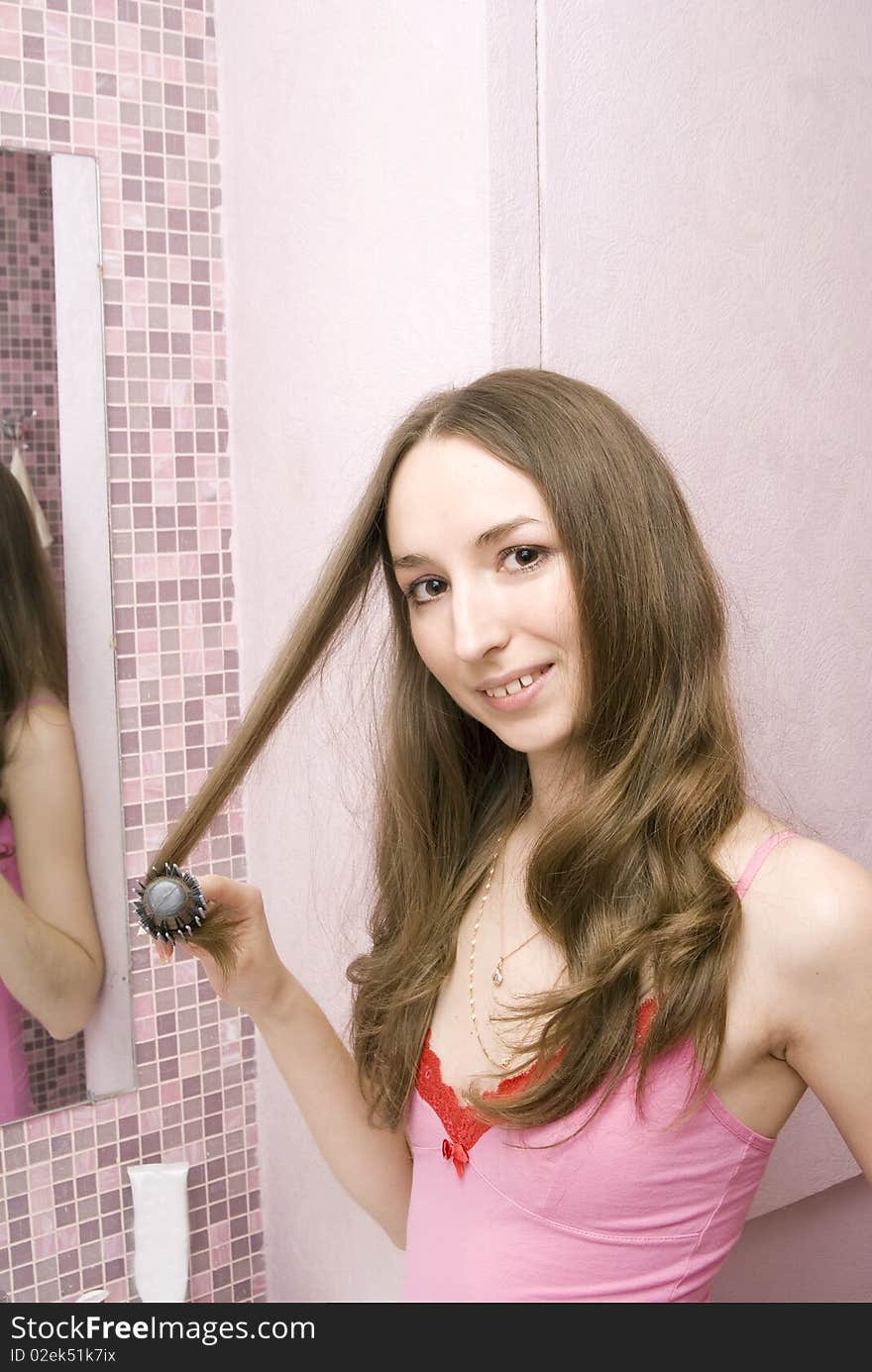 Beautiful girl combs hair a hairbrush