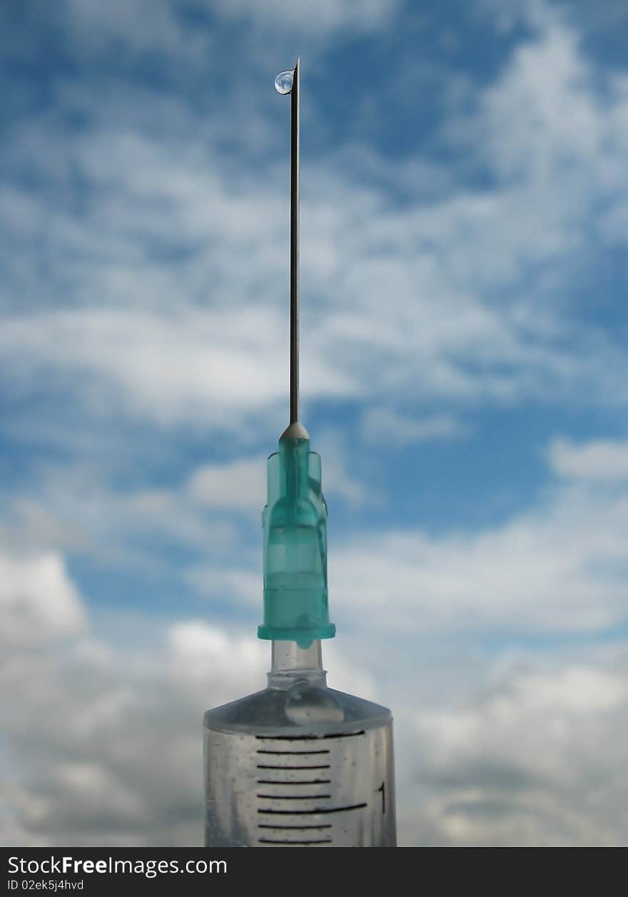 Disposable syringe against the blue sky