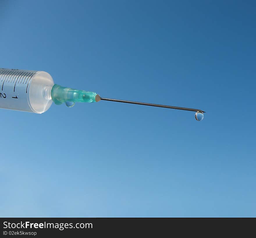 Disposable syringe against the blue sky