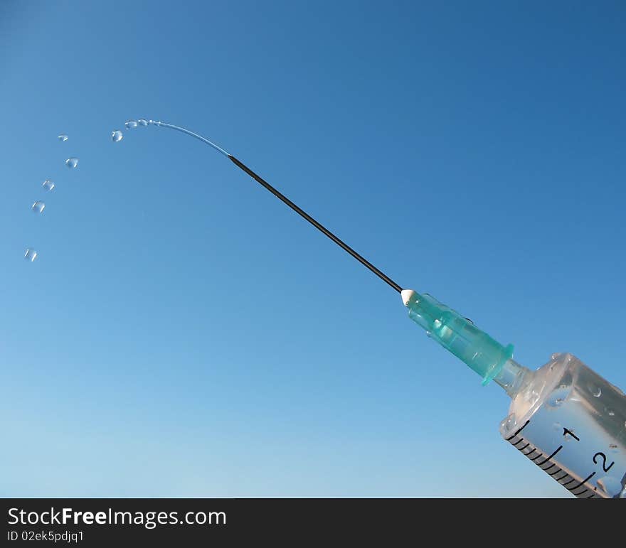 Disposable syringe against the blue sky