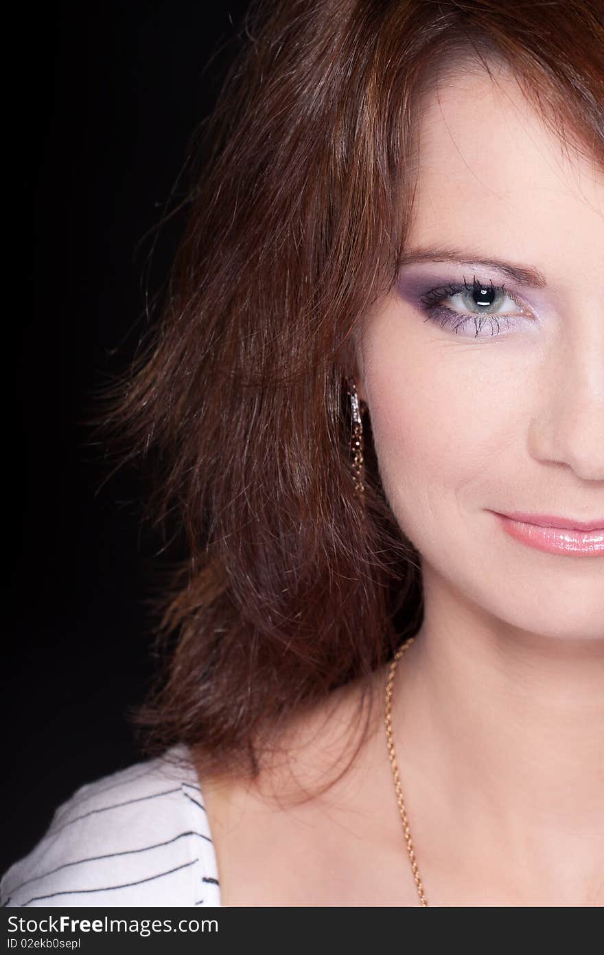 Half portrait of a girl face with makeup against black background