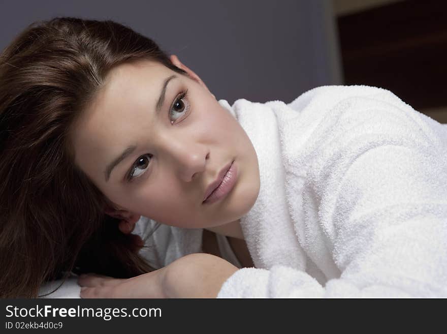 Beautiful young women in the spa, looking at camera, brunette, wearing white towel robe. Beautiful young women in the spa, looking at camera, brunette, wearing white towel robe.