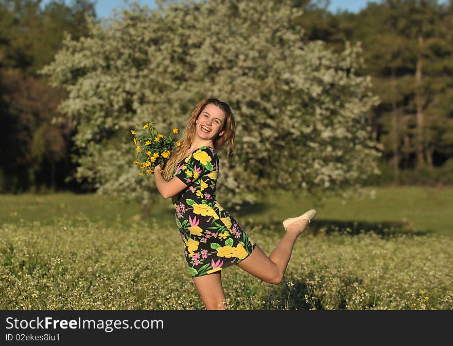 Beautiful Young Woman Jumping In Blooming Meadow