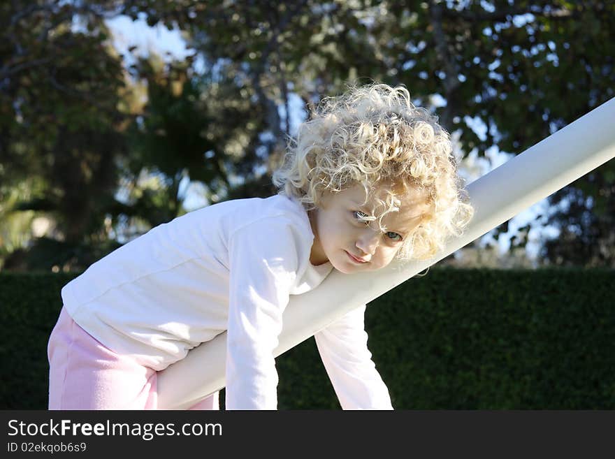 Child hanging from a goal post in a playground. Child hanging from a goal post in a playground