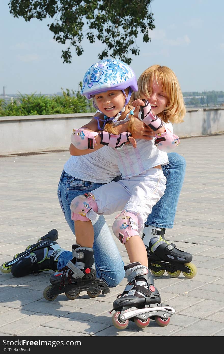 Daughter and mother having fun on in-line skates on a sunny summer day. Daughter and mother having fun on in-line skates on a sunny summer day