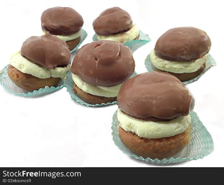 Cakes with cream and chocolate icing , isolated on a white background