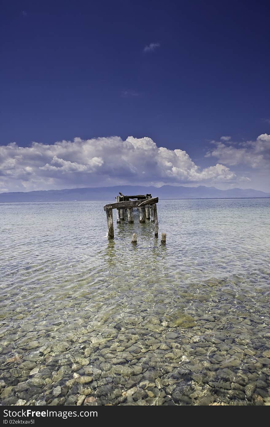 Decayed jetty in a lake blue skies clear water wit