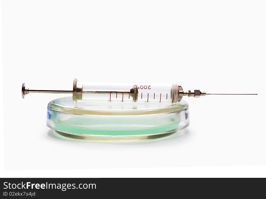 Transparent chemical glassware with green solution with syringe isolated on white. Transparent chemical glassware with green solution with syringe isolated on white