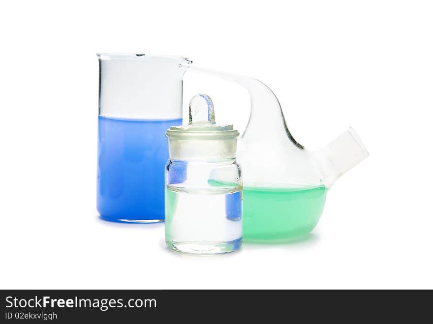 Transparent chemical glassware with green and blue solution isolated on white