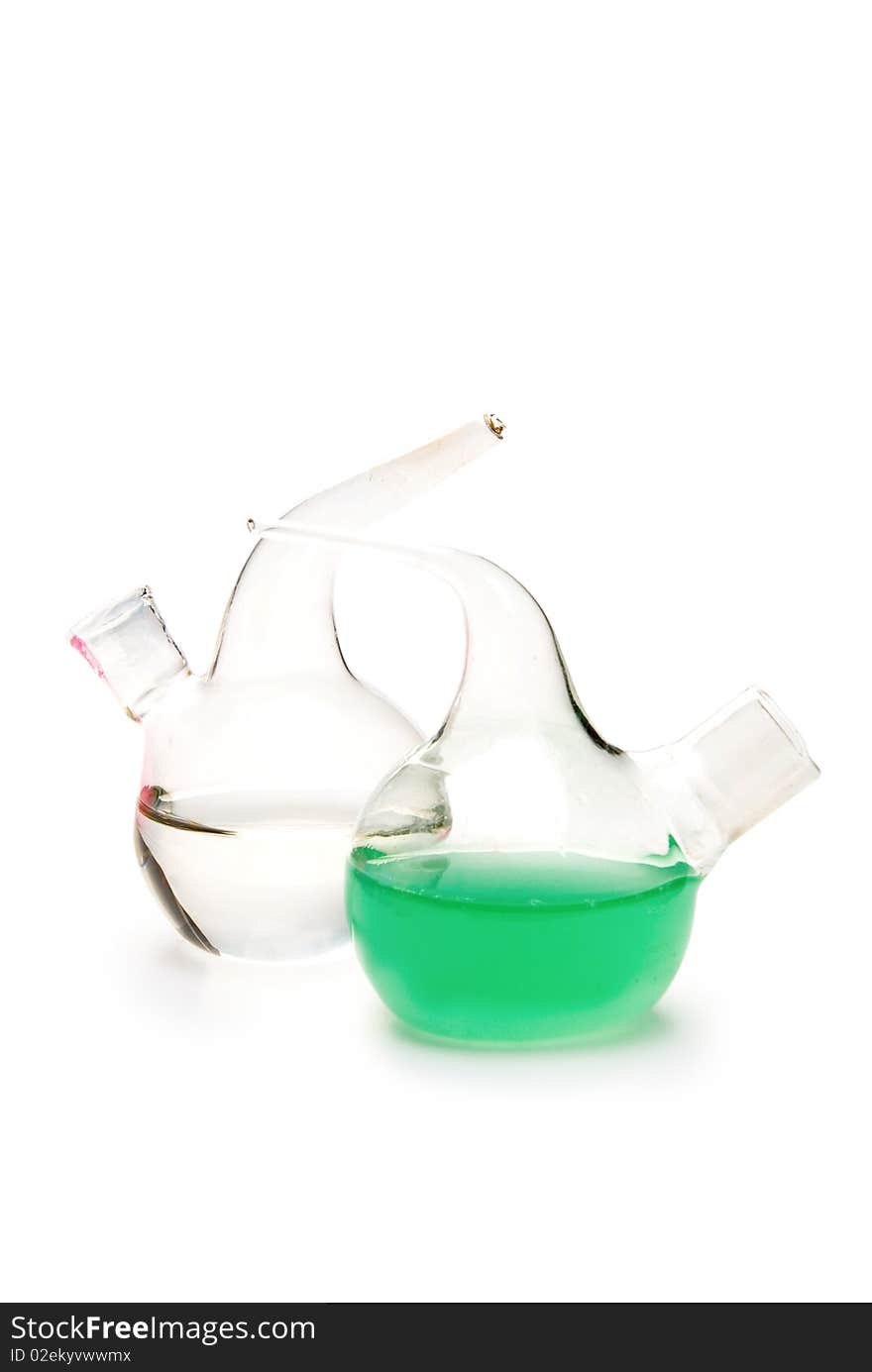 Transparent chemical glassware with green and blue solution isolated on white