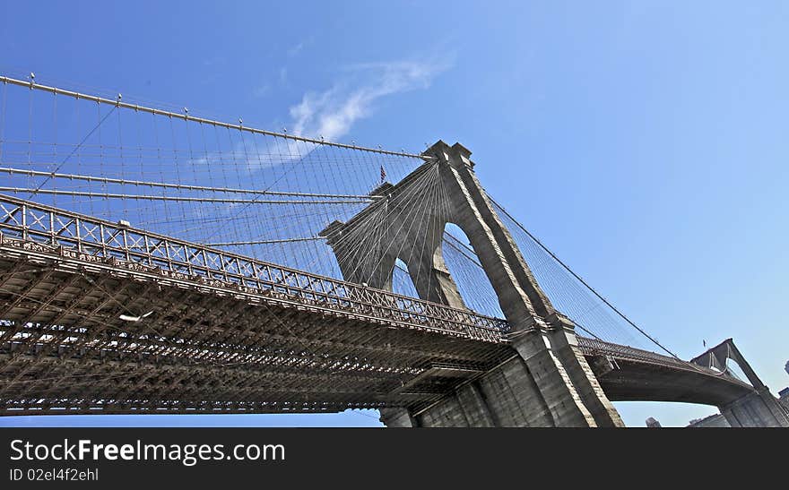 Brooklyn bridge NYC under perfect day light, view from Manhattan's waterfront mini-beach