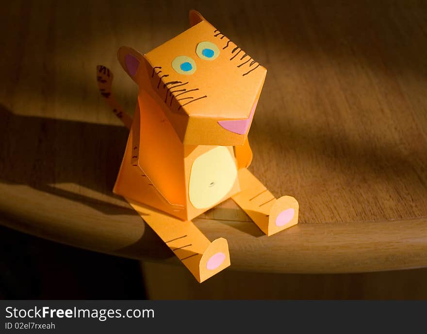 The tiger from an orange paper sits on a table