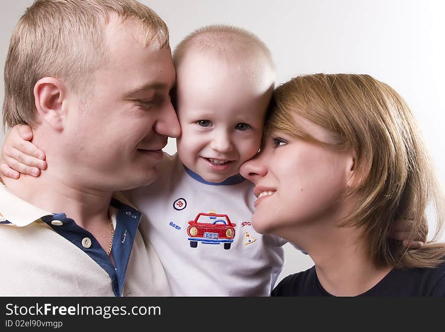 Baby is hugging his parents. Parents are looking very tenderly on thier son. Baby is hugging his parents. Parents are looking very tenderly on thier son