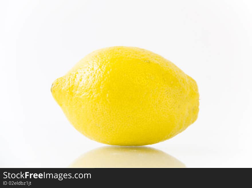 Brightly yellow lemon on a white. Brightly yellow lemon on a white