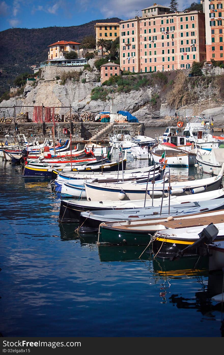 A landscape of a typical village in the Italian Riviera. Here is Camogli between Genoa and Portofino, the boats moored in the port of Camogli reflected in the water. A landscape of a typical village in the Italian Riviera. Here is Camogli between Genoa and Portofino, the boats moored in the port of Camogli reflected in the water.