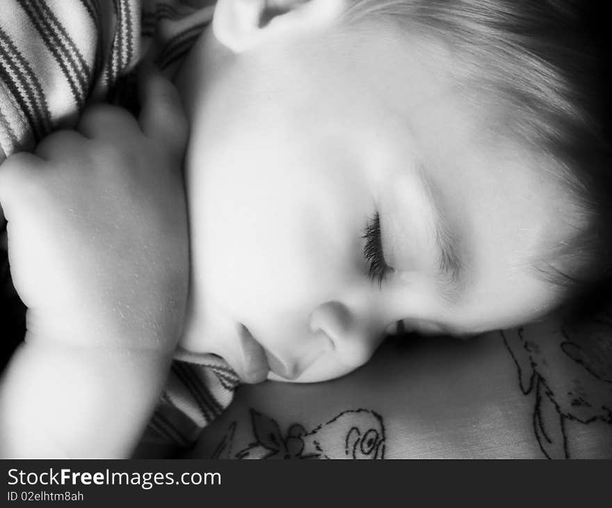 The boy serenely sleeps. Soft focus.Black & white. The boy serenely sleeps. Soft focus.Black & white.