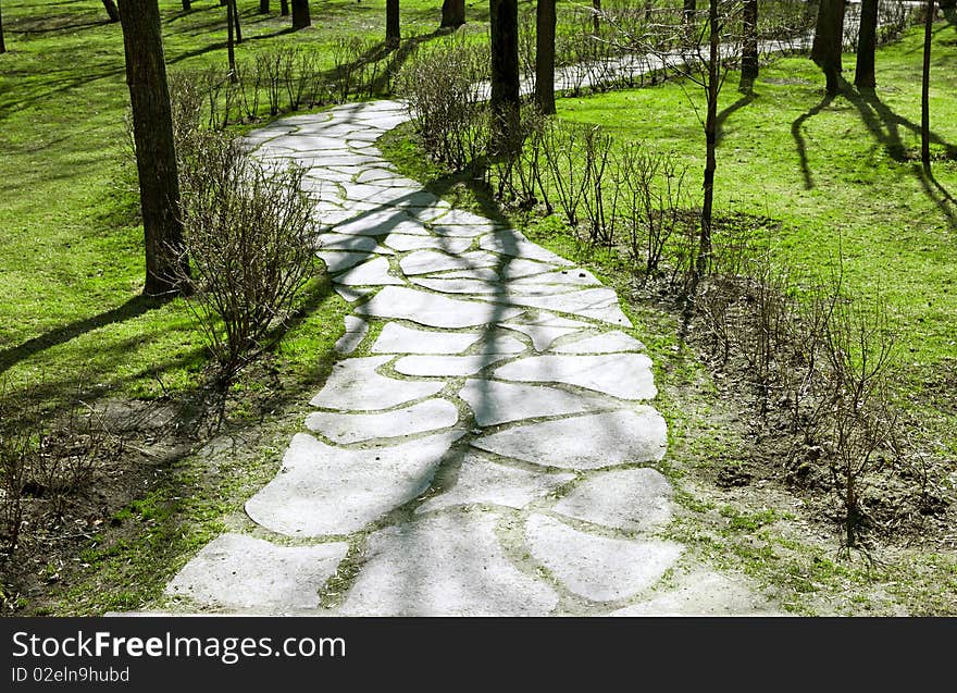 Stone path in the park with tree shadows. Stone path in the park with tree shadows