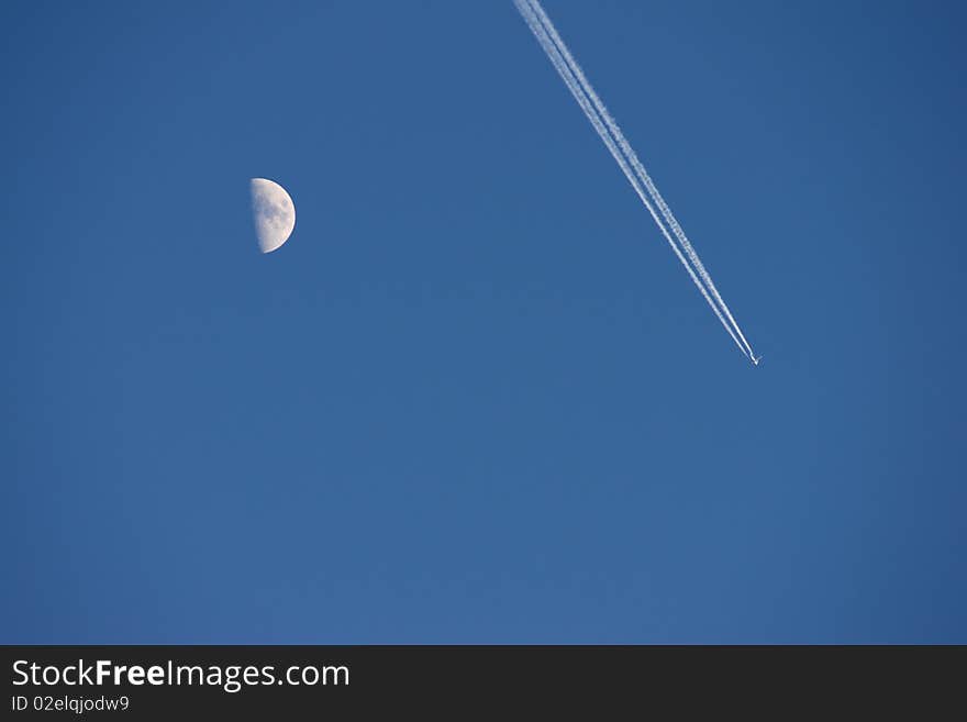 Airplane is flying over the moon in blue sky. Airplane is flying over the moon in blue sky