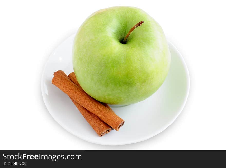 Apple and cinnamon on a plate on a white background