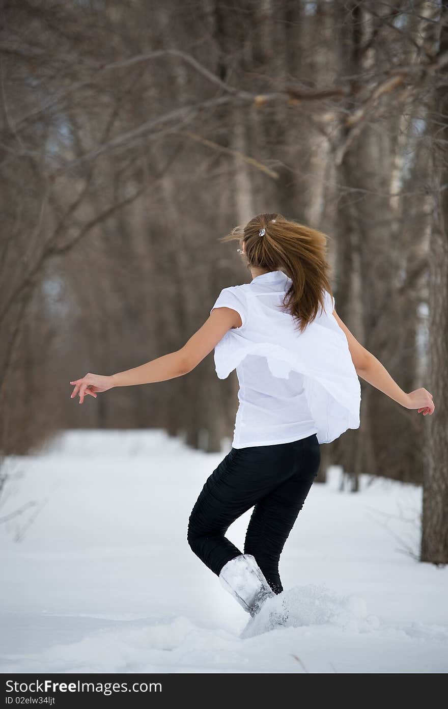 Positive emotion. Fashion model posing in snowdrift in wood