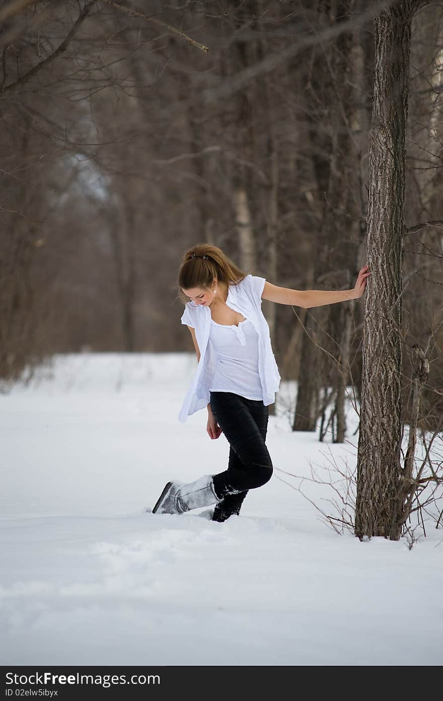 Fashion model posing in snowdrift in wood. Fashion model posing in snowdrift in wood