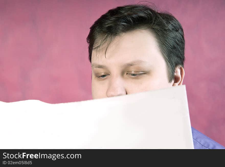 Reading newspaper, studio portrait on pink