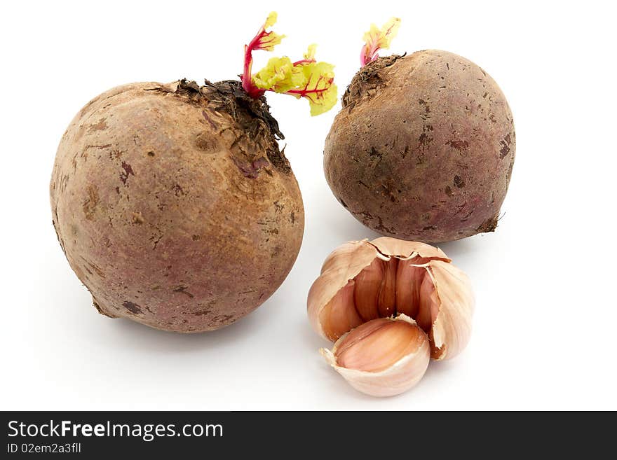 Two beets and garlic with sprouts on white background. Two beets and garlic with sprouts on white background