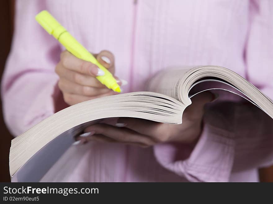 Businesswoman with yellow marker taking notes