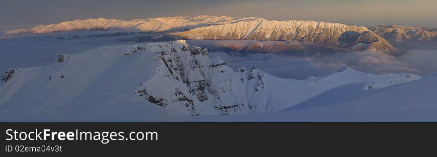 Panoramic Picture with sunrise in Carpathians Mountain, Romania, Bucegi Summit, from Vf.Omu Peak, and Piatra Craiului Mountain far away. Panoramic Picture with sunrise in Carpathians Mountain, Romania, Bucegi Summit, from Vf.Omu Peak, and Piatra Craiului Mountain far away.