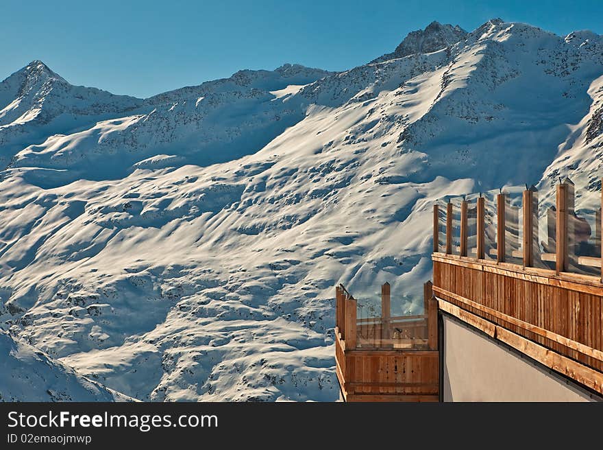 Mountain restaurant balcony view on high peaks in snow. Mountain restaurant balcony view on high peaks in snow.