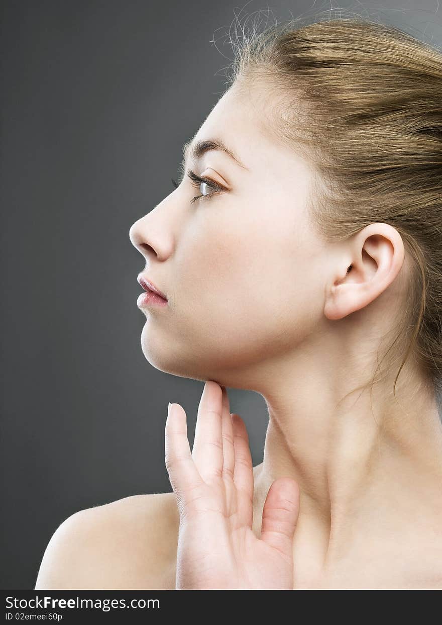 Profile portrait of beautiful girl on grey background