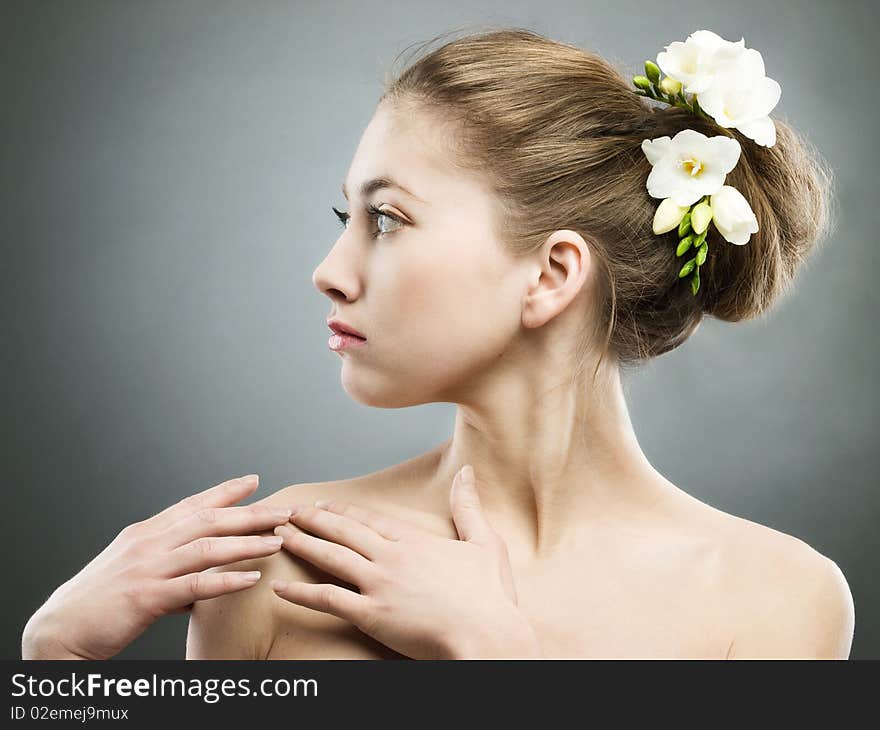 Portrait of beautiful girl with white freesia on grey background. Portrait of beautiful girl with white freesia on grey background