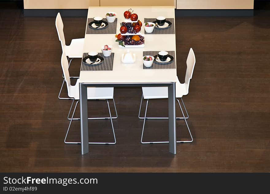 A table set prepared for an elegant breakfast with coffee cups and fruit. A table set prepared for an elegant breakfast with coffee cups and fruit